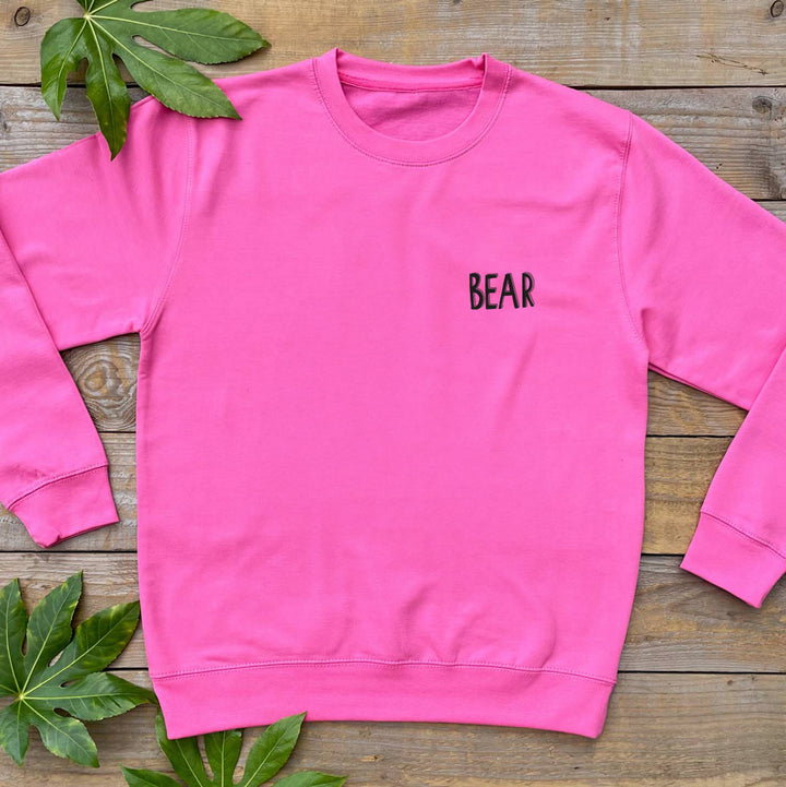 pink jumper with bear text