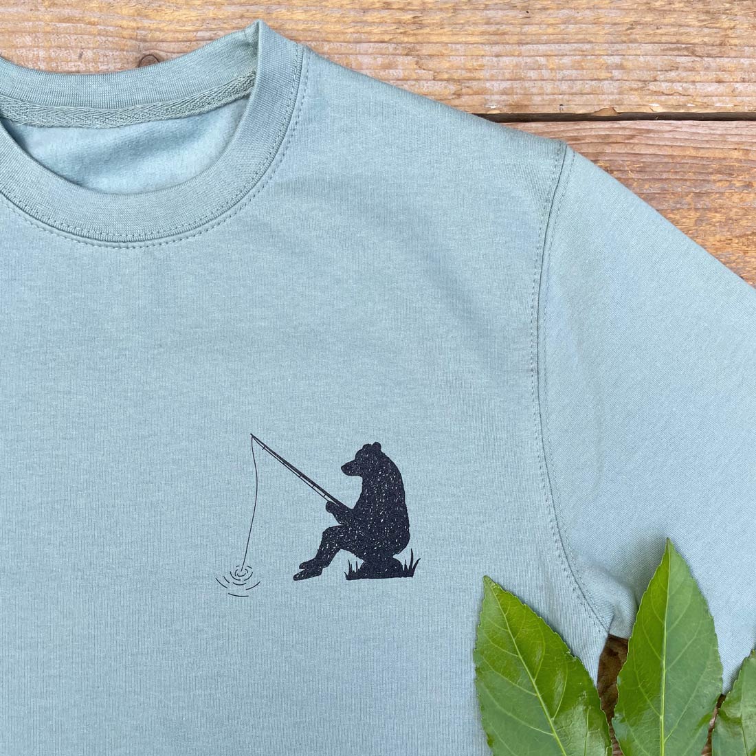 bear sat with fishing rod jumper