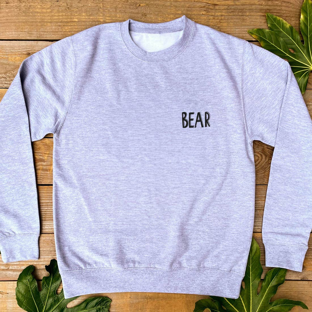 grey jumper with bear text